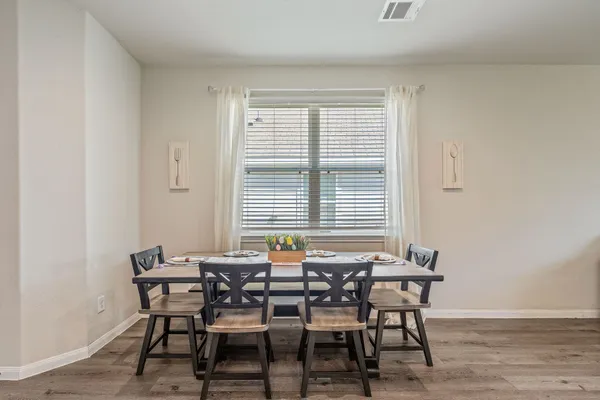 a dining room with furniture and wooden floor