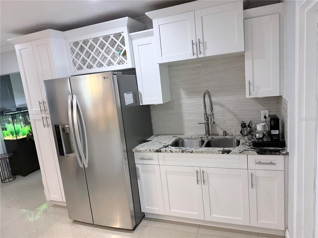 2719 West Braddock Street Tampa, FL 33607 - Photo 12 of 29 a kitchen with stainless steel appliances granite countertop a refrigerator a stove a sink and white cabinets