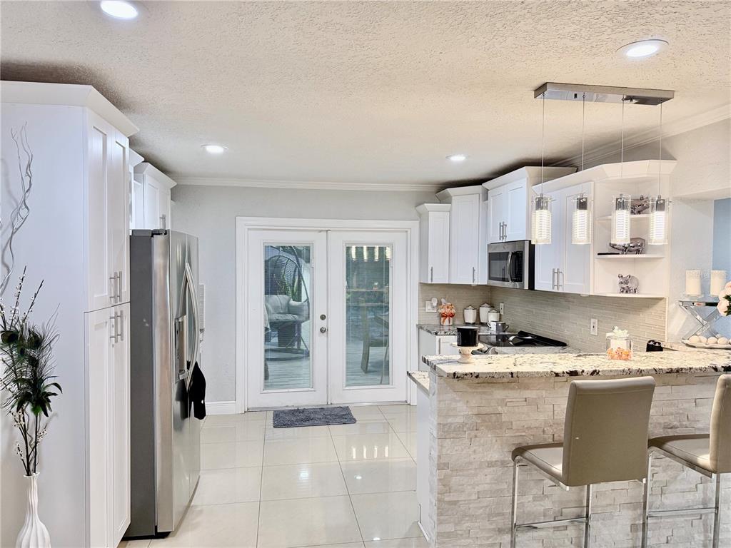 2719 West Braddock Street Tampa, FL 33607 - Photo 10 of 29 a kitchen with stainless steel appliances kitchen island granite countertop a refrigerator and a stove top oven