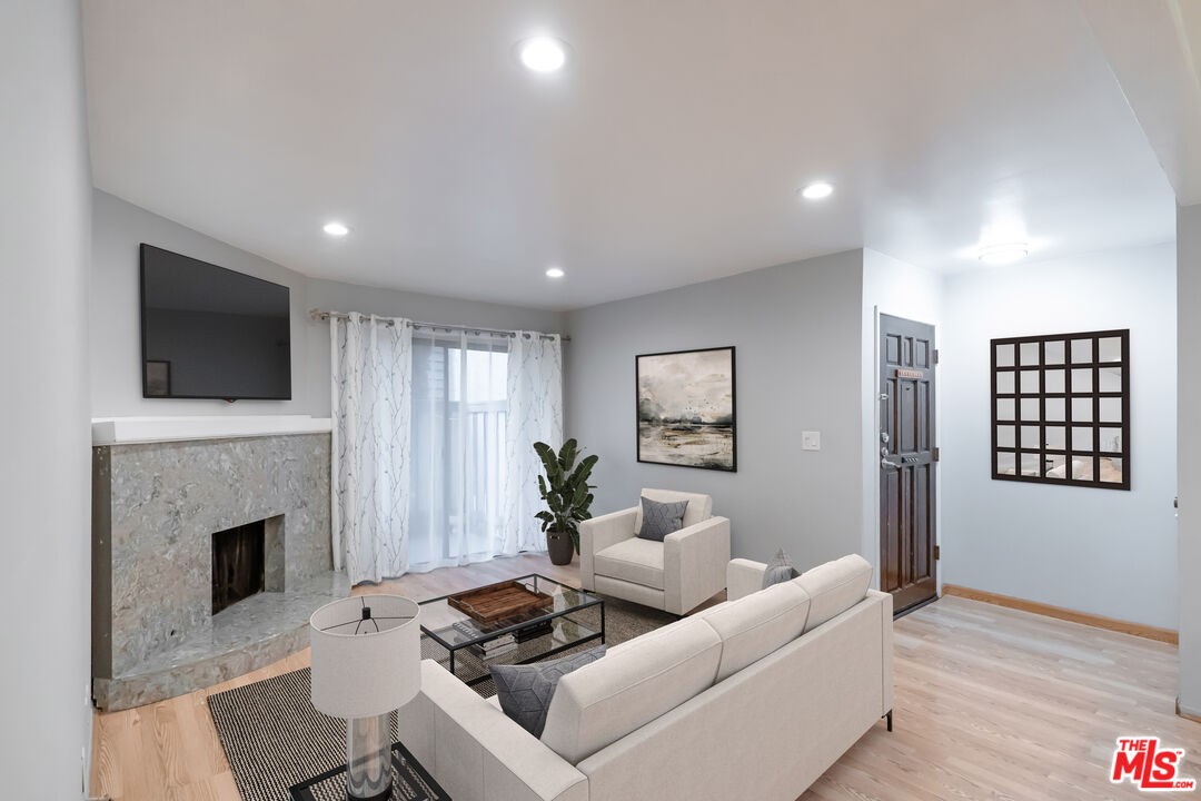 a living room with furniture a fireplace and a flat screen tv