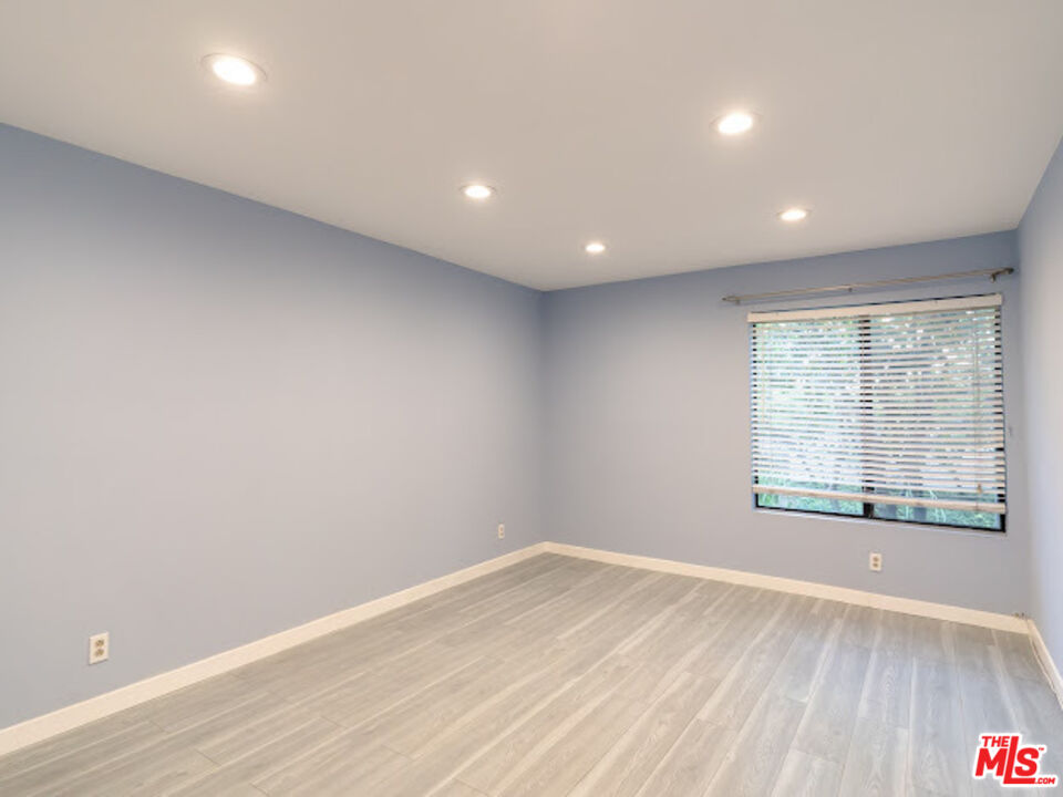 15511 Sherman Way, Unit 17 Van Nuys, CA 91406 - Photo 14 of 47 an empty room with wooden floor and windows