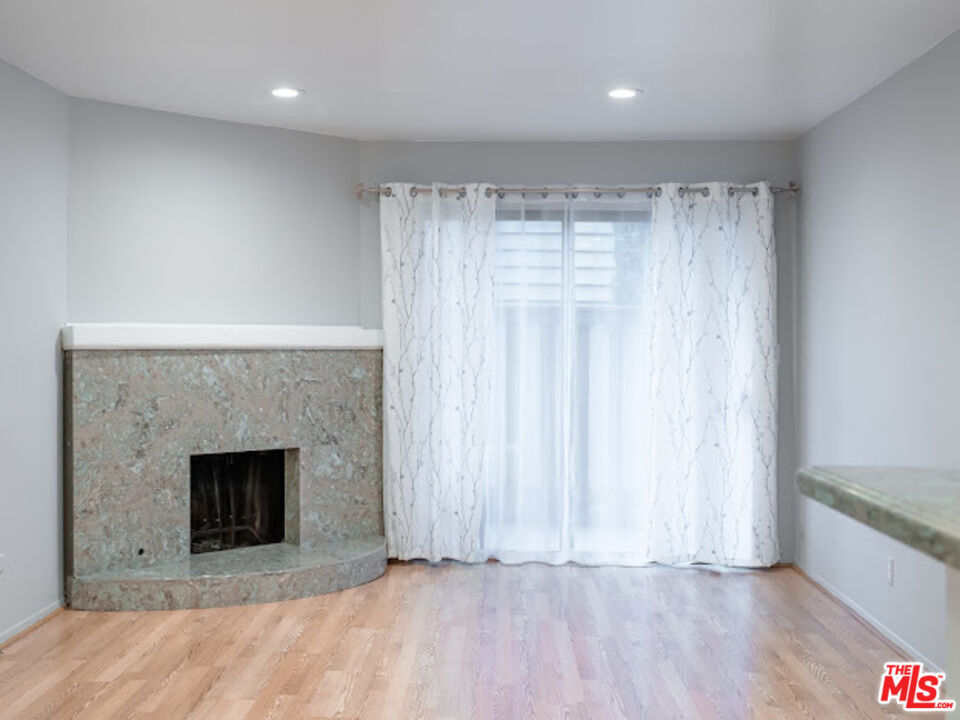 15511 Sherman Way, Unit 17 Van Nuys, CA 91406 - Photo 29 of 47 a view of an empty room with a fireplace and a window
