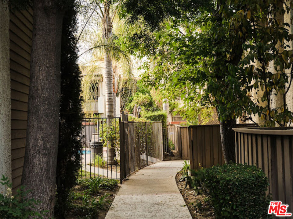 15511 Sherman Way, Unit 17 Van Nuys, CA 91406 - Photo 45 of 47 a view of a pathway of a house with wooden fence