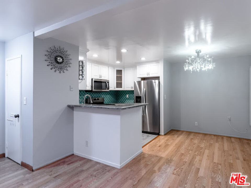 15511 Sherman Way, Unit 17 Van Nuys, CA 91406 - Photo 6 of 47 a kitchen with stainless steel appliances granite countertop a refrigerator and a sink