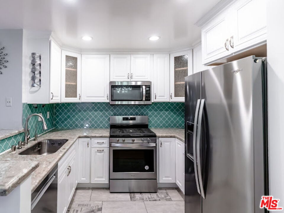 15511 Sherman Way, Unit 17 Van Nuys, CA 91406 - Photo 7 of 47 a kitchen with a stove microwave and refrigerator