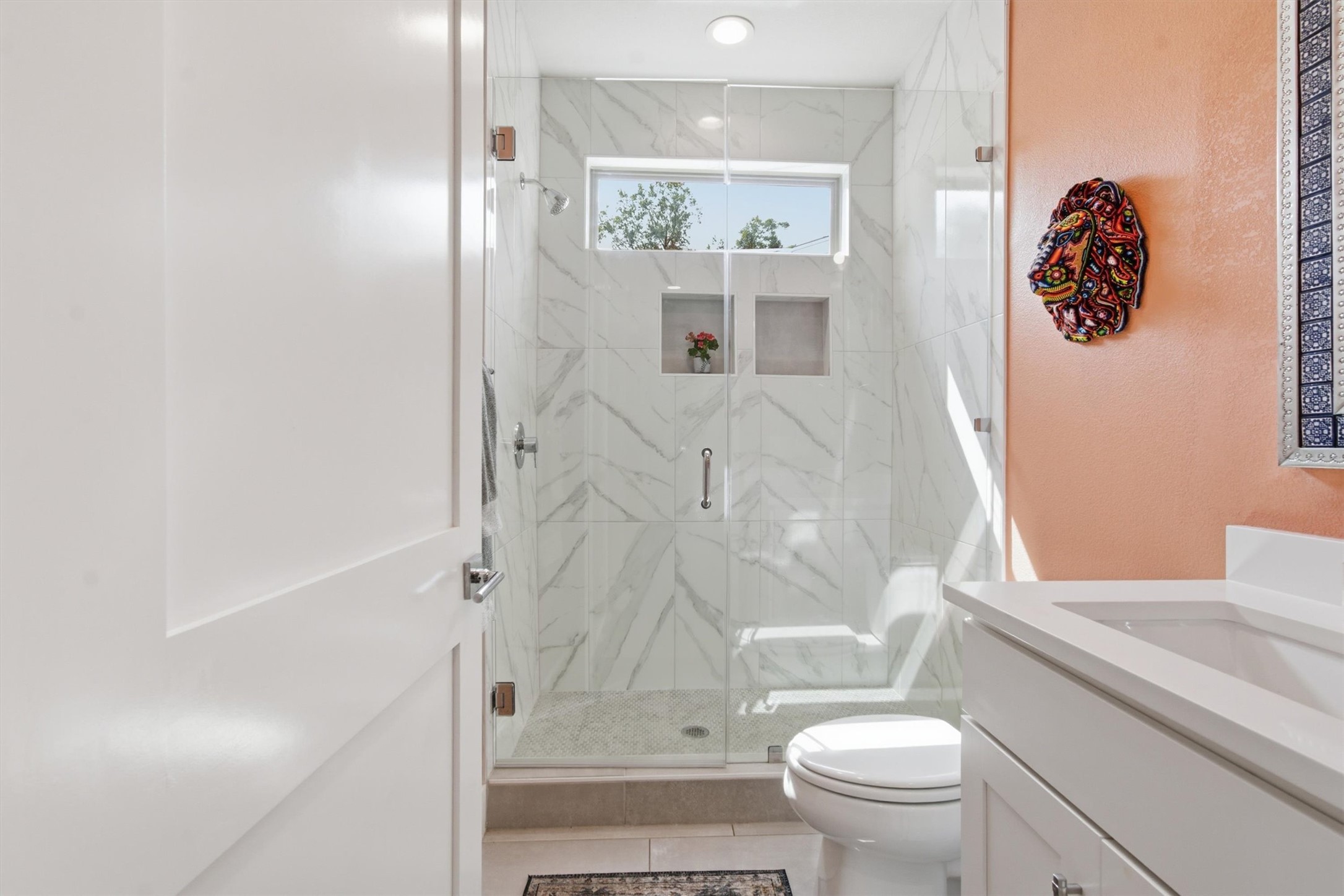 2710 Zaragosa Street, Unit A Austin, TX 78702 - Photo 13 of 29 Spa-inspired bath with a marble herringbone walk-in shower, frameless glass enclosure, and built-in niche. Main level
