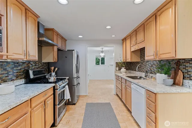 a kitchen with stainless steel appliances granite countertop a sink stove and refrigerator