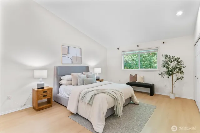 a bedroom with a white bed and a plant