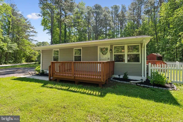 a view of a house with a backyard and a wooden deck