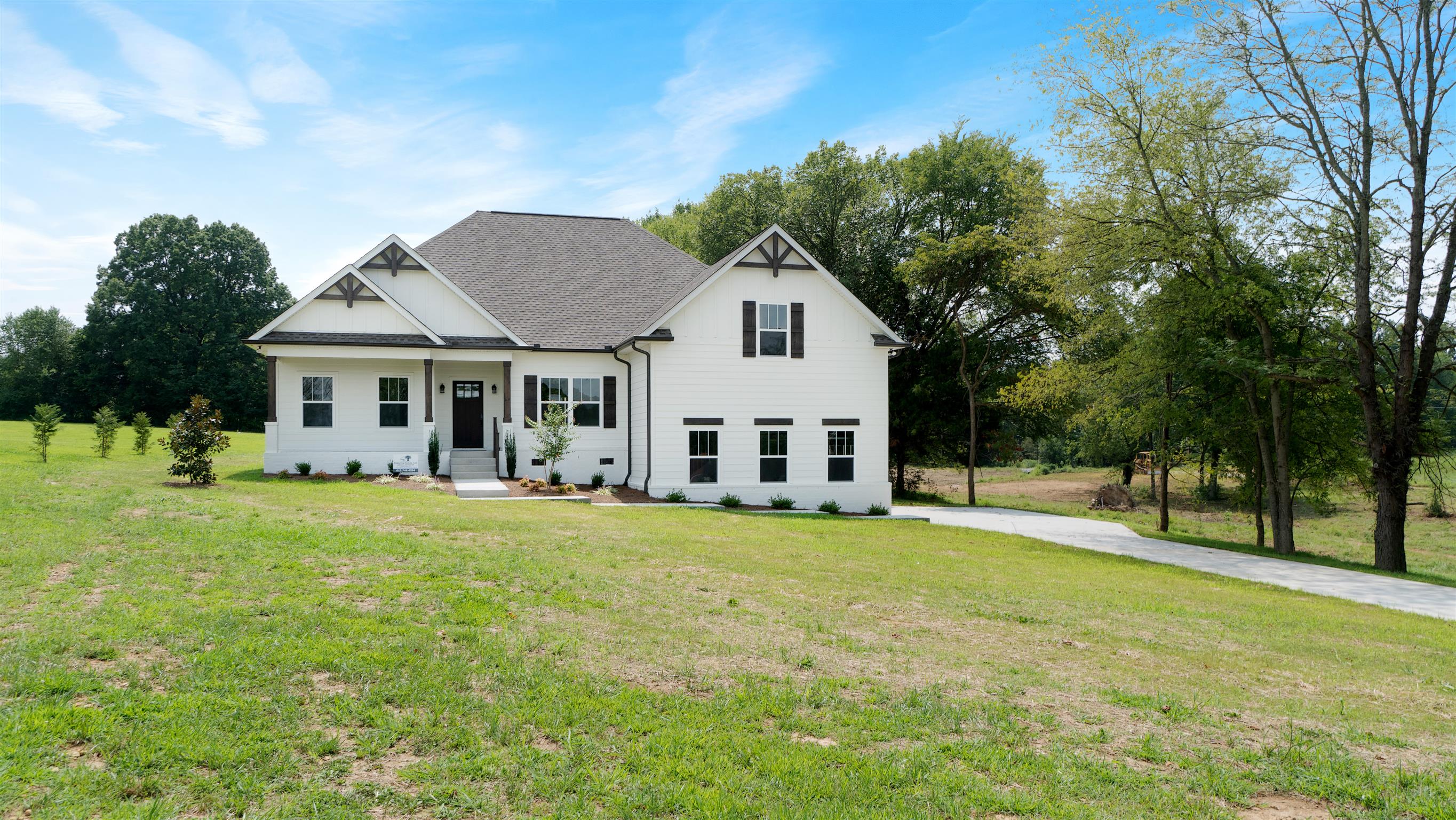 a front view of a house with a garden and trees