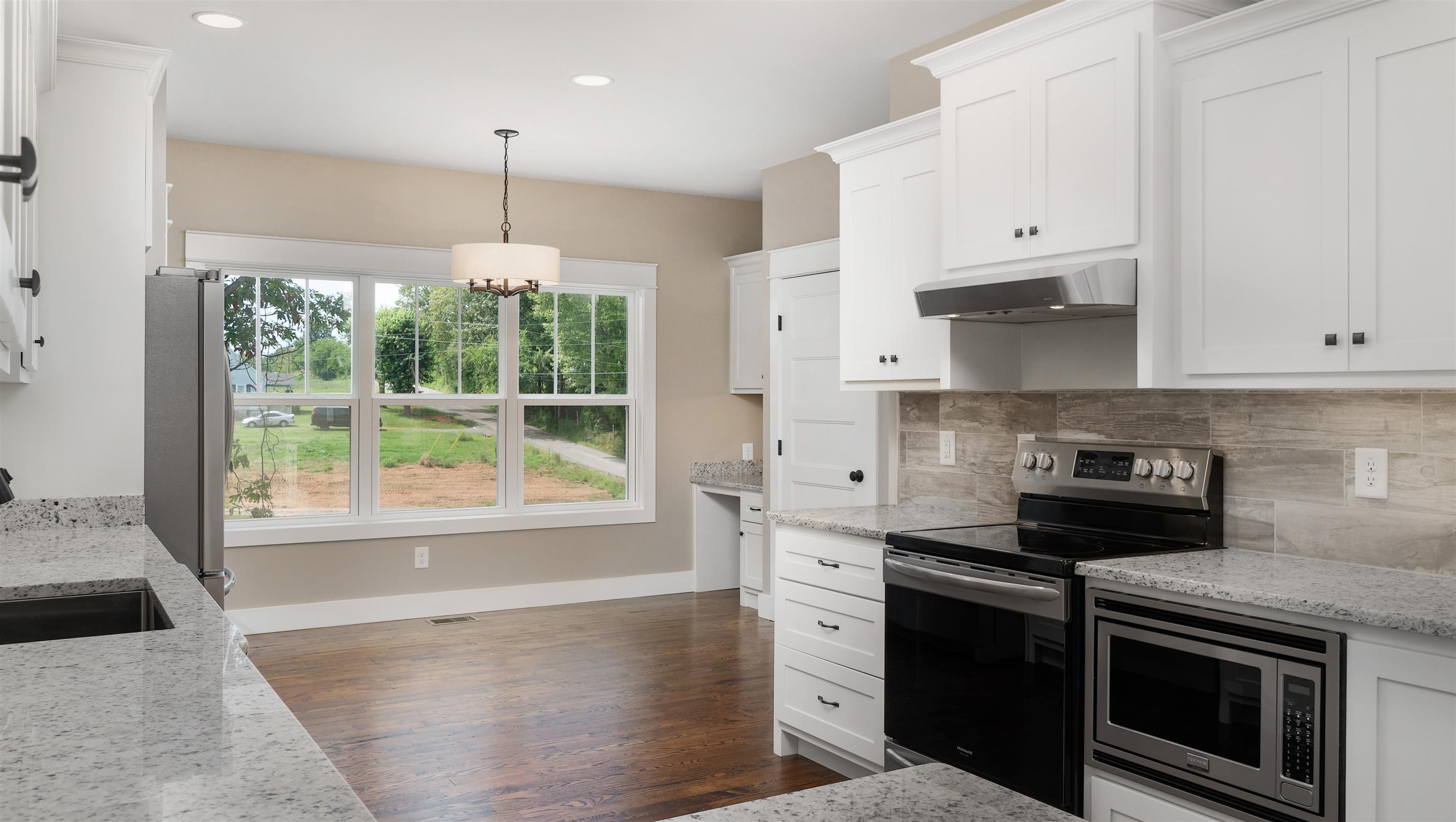 485 Tom Link Road Cottontown, TN 37048 - Photo 6 of 30 a kitchen with granite countertop a stove a sink and a white cabinets