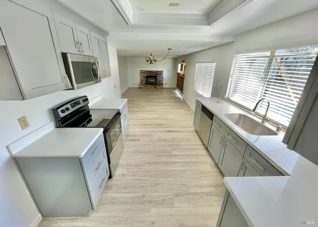 a kitchen with stainless steel appliances granite countertop a sink and a stove