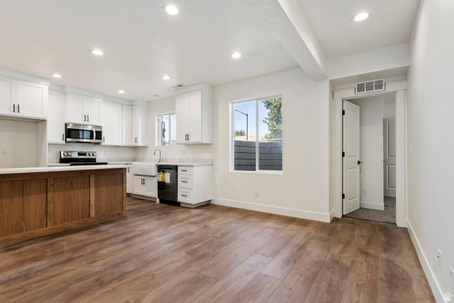 504 North 650 E Street Springville, UT 84663 - Photo 28 of 36 Open-concept living area featuring wood-finish flooring, recessed lighting, and a kitchen with white cabinetry