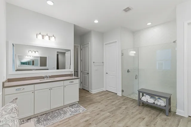 a en suite bathroom with a double vanity sink and a mirror