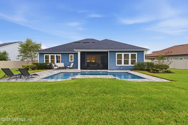 an aerial view of residential houses with outdoor space and swimming pool