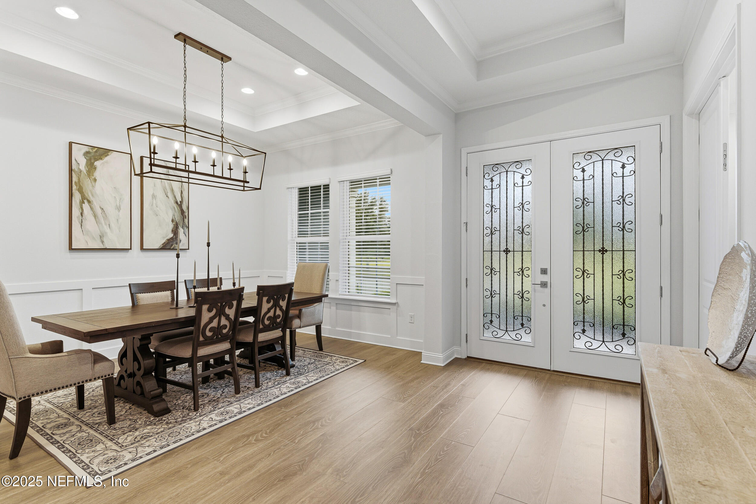 375 Kirkside Avenue St. Augustine, FL 32095 - Photo 6 of 49 a dining room with wooden floor a chandelier a glass table and chairs
