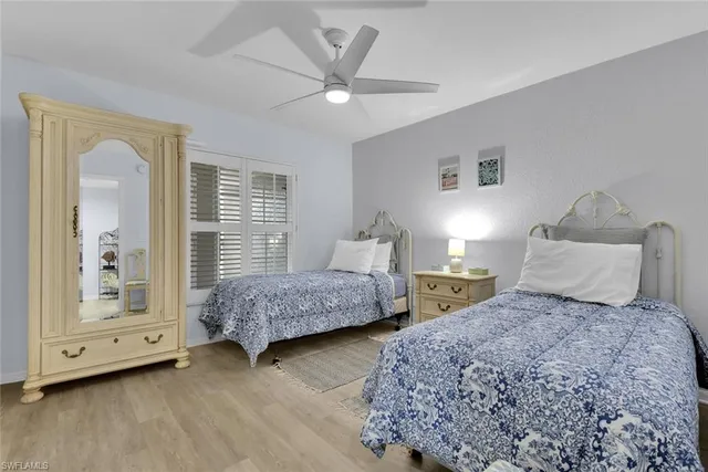 a bedroom with two beds and large windows