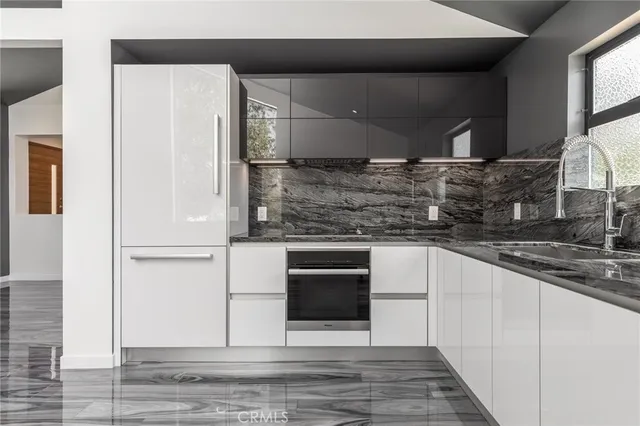 a view of an empty room with wooden floor and a bathroom