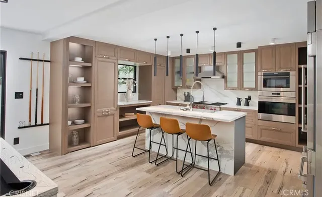 a kitchen with stainless steel appliances granite countertop a stove refrigerator and a fireplace