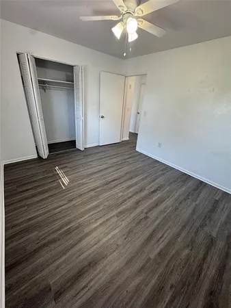 an empty room with wooden floor and closet area
