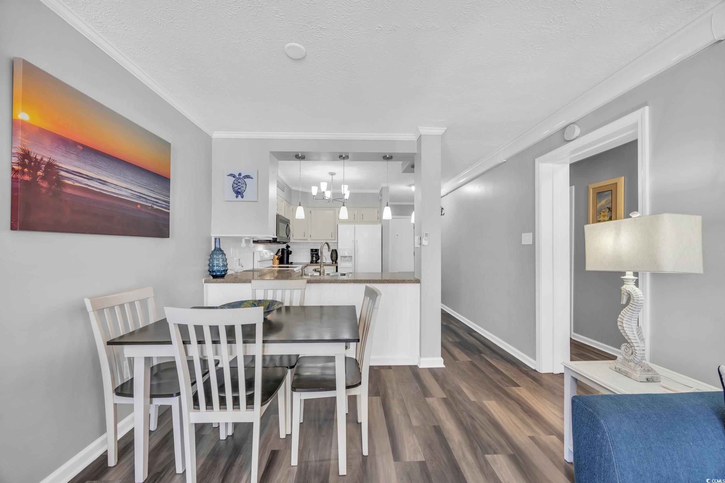 2405 South Ocean Boulevard, Unit 306 North Myrtle Beach, SC 29582 - Photo 9 of 37 Dining space featuring crown molding, dark hardwoo