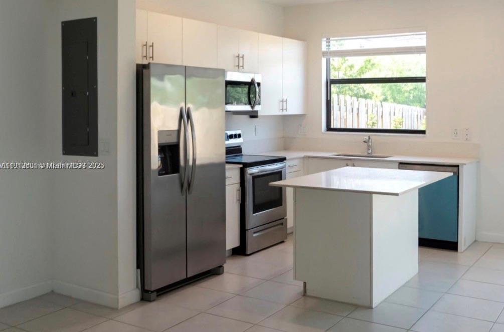 561 Northeast 208th Terrace, Unit 561 Miami, FL 33179 - Photo 19 of 31 a kitchen with stainless steel appliances granite countertop a refrigerator and a sink