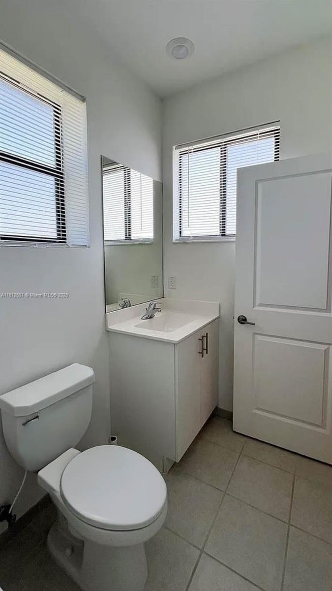 561 Northeast 208th Terrace, Unit 561 Miami, FL 33179 - Photo 21 of 31 a bathroom with a toilet sink and mirror