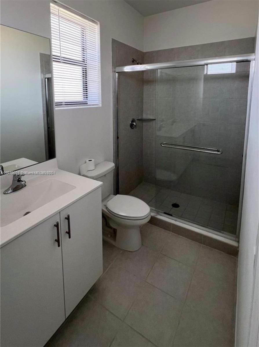 561 Northeast 208th Terrace, Unit 561 Miami, FL 33179 - Photo 23 of 31 a bathroom with a sink a toilet and shower