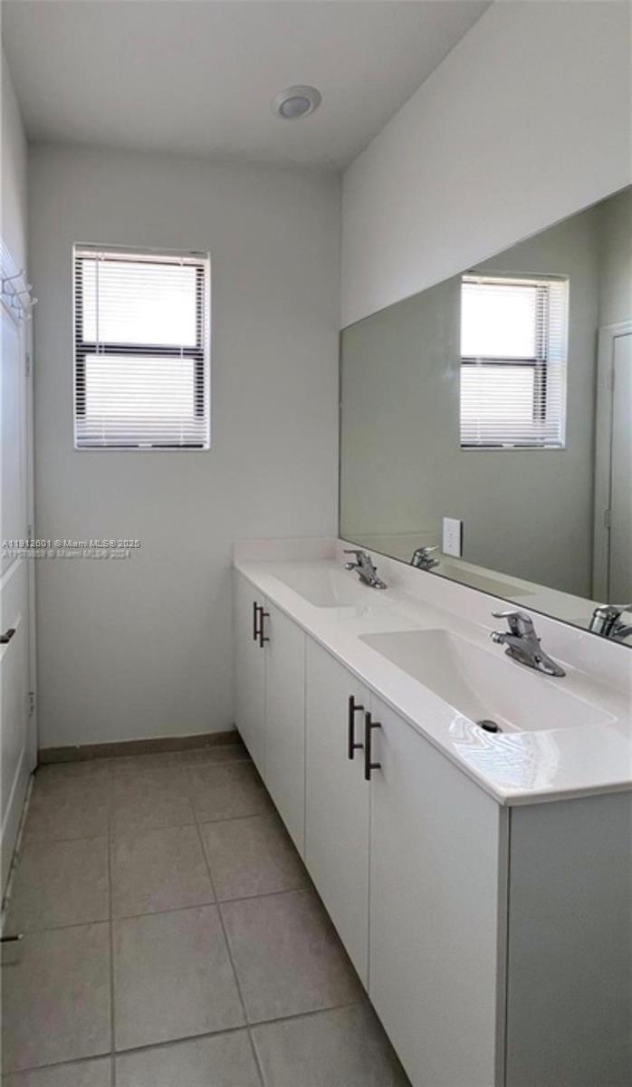 561 Northeast 208th Terrace, Unit 561 Miami, FL 33179 - Photo 24 of 31 a bathroom with a sink and a mirror