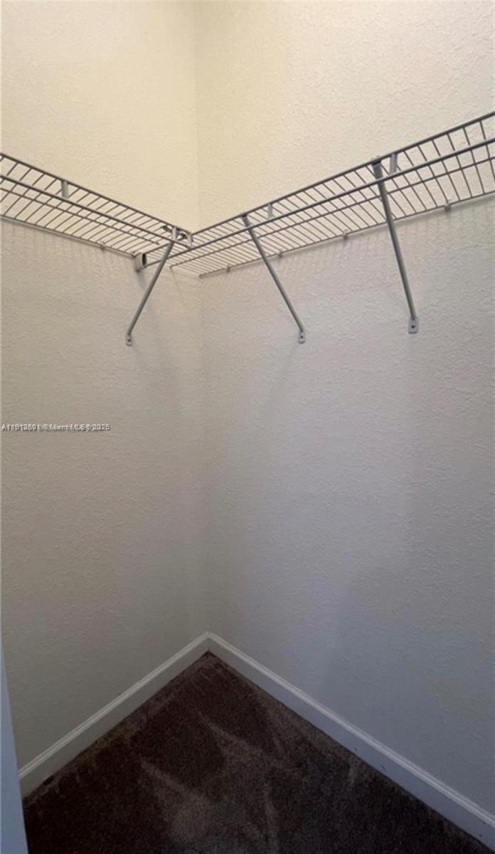 561 Northeast 208th Terrace, Unit 561 Miami, FL 33179 - Photo 28 of 31 a view of a room with racks on the wall