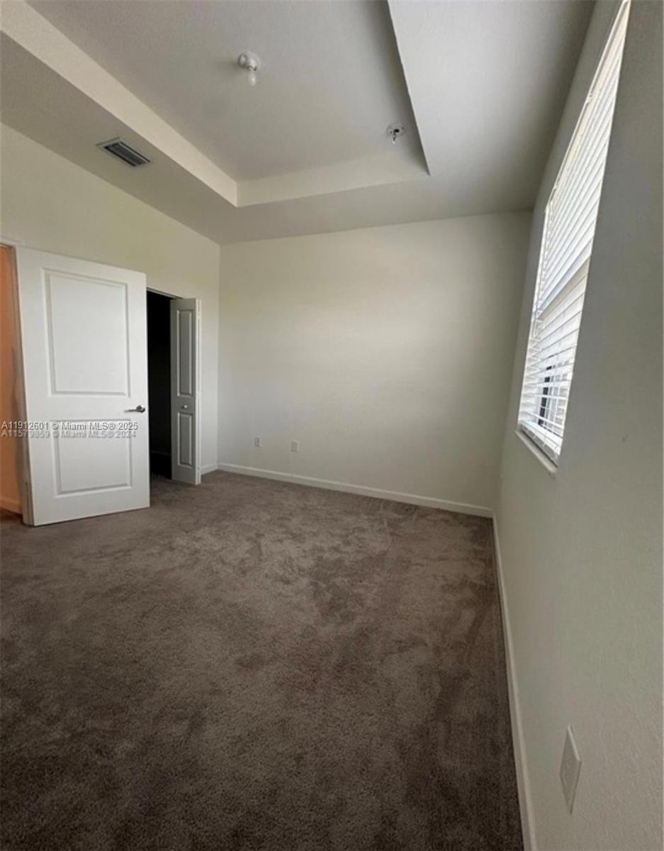 561 Northeast 208th Terrace, Unit 561 Miami, FL 33179 - Photo 31 of 31 an empty room with windows