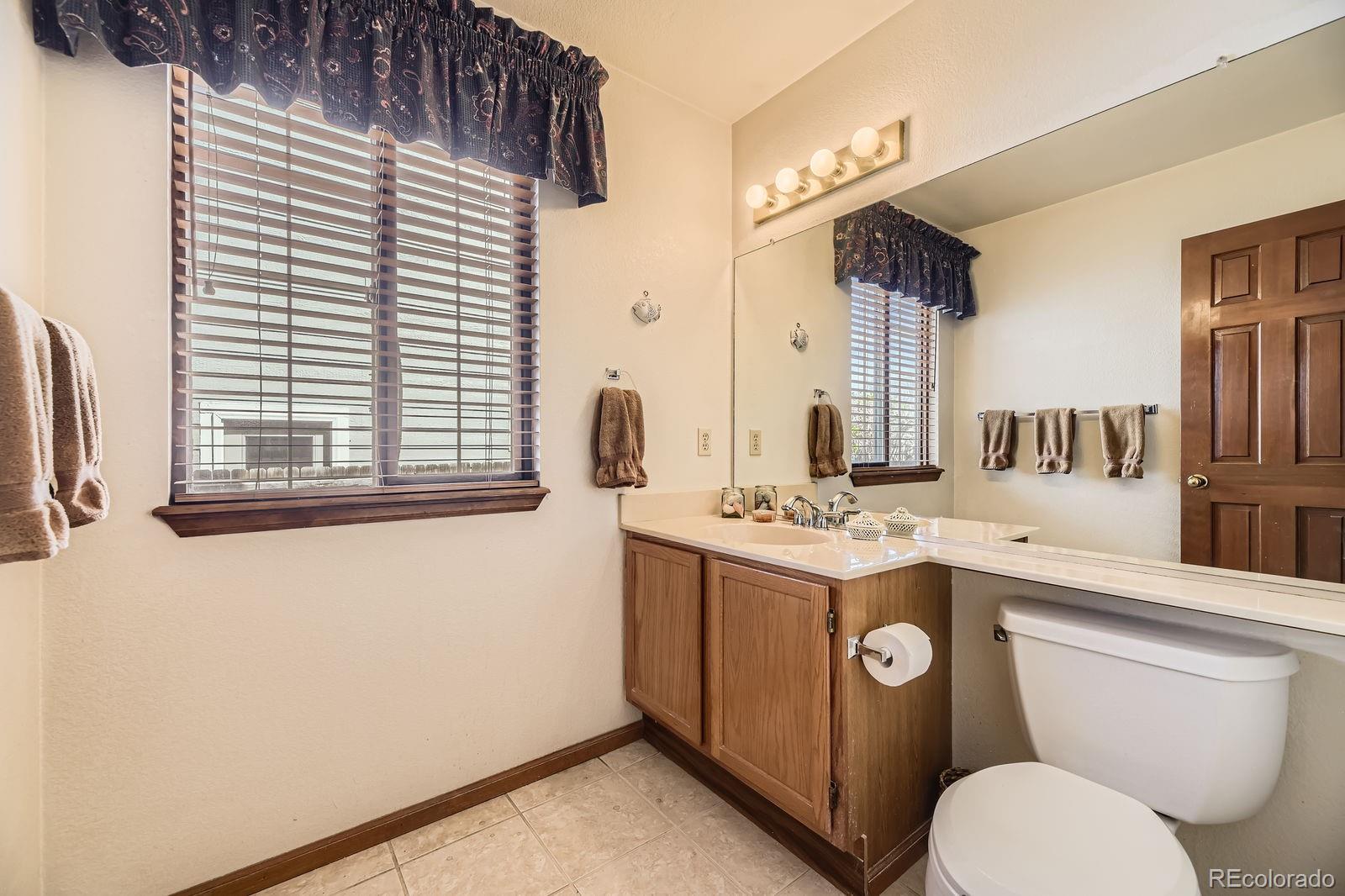 6726 Taft Circle Arvada, CO 80004 - Photo 13 of 41 a view of bathroom with a toilet sink and mirror