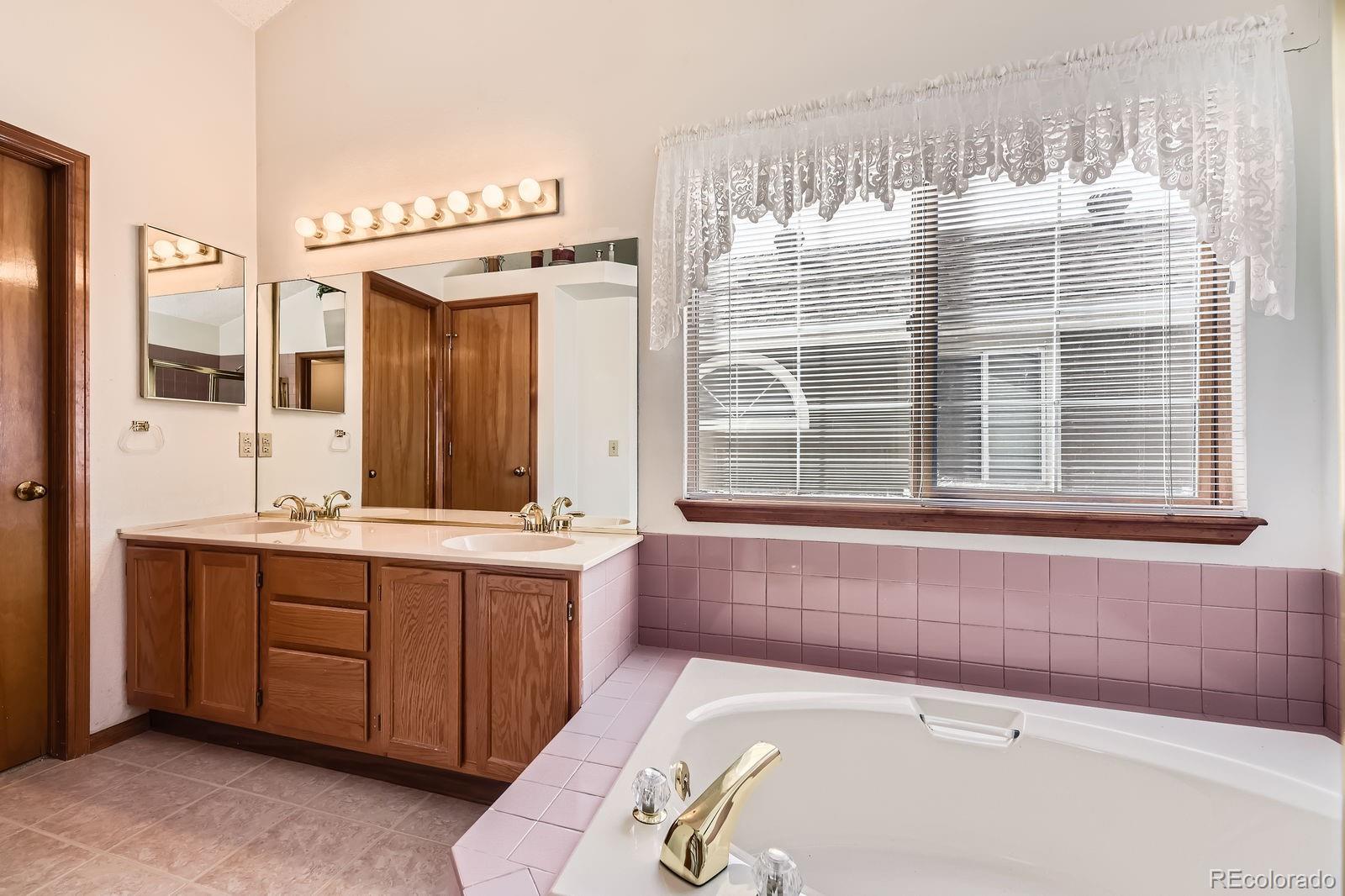 6726 Taft Circle Arvada, CO 80004 - Photo 17 of 41 a bathroom with a tub sink and mirror