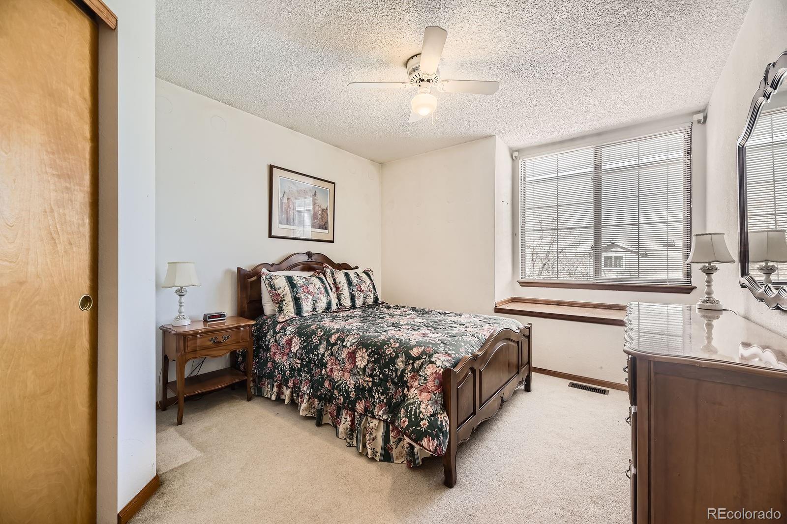 6726 Taft Circle Arvada, CO 80004 - Photo 20 of 41 a spacious bedroom with a bed and a large window with the outer view