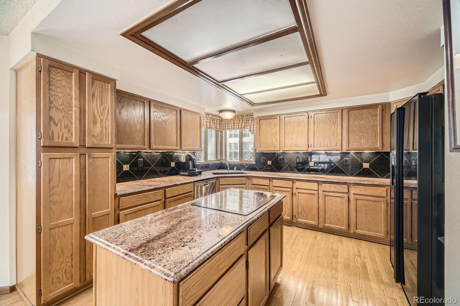 6726 Taft Circle Arvada, CO 80004 - Photo 7 of 41 a kitchen with a refrigerator a sink and cabinets