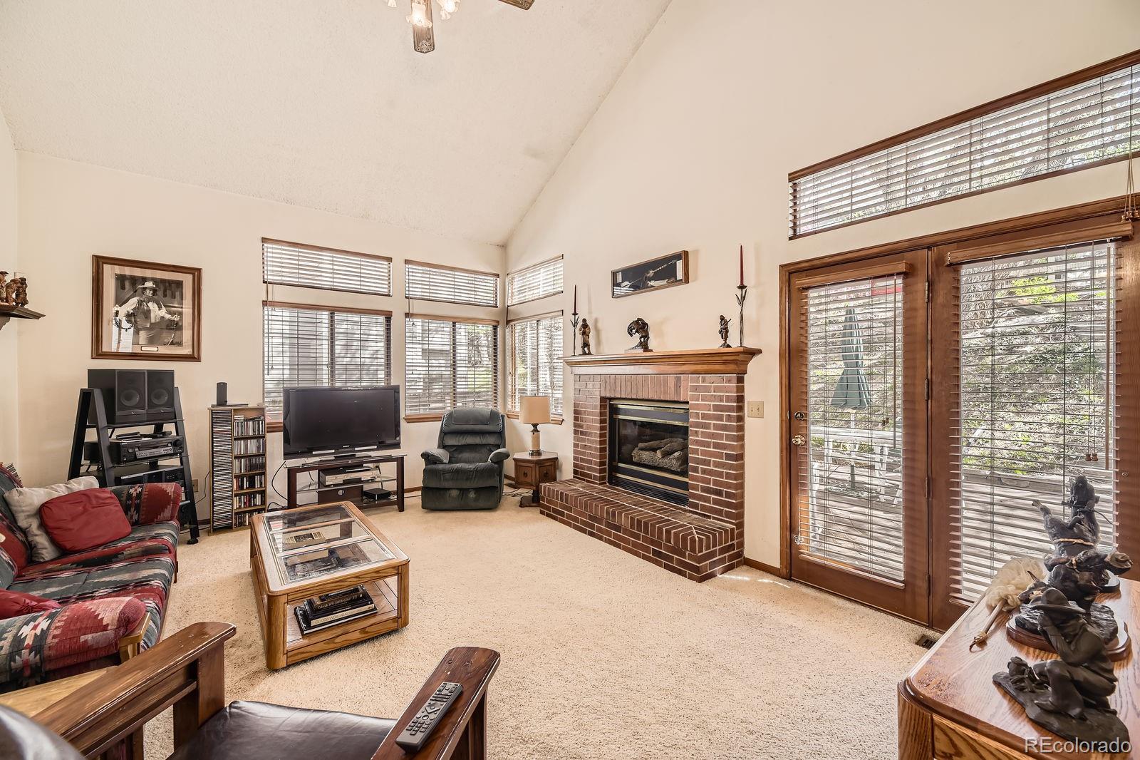 6726 Taft Circle Arvada, CO 80004 - Photo 10 of 41 a living room with furniture a flat screen tv and a fireplace