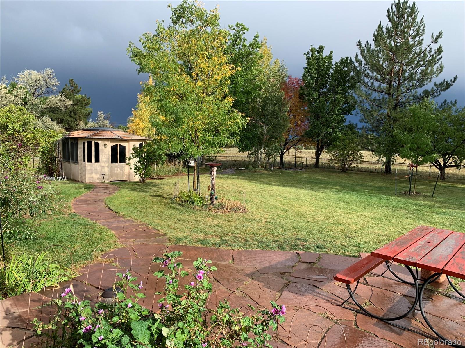 2701 Pheasant Run Berthoud, CO 80513 - Photo 38 of 40 a view of a backyard with table and chairs potted plants and large tree