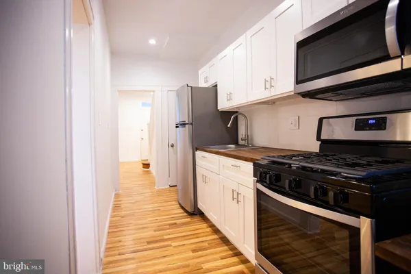 a kitchen with stainless steel appliances a stove microwave and cabinets