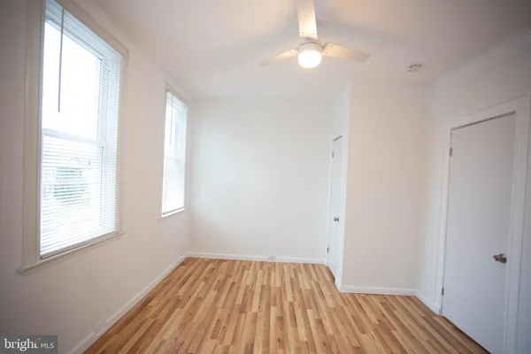 a view of a room with wooden floor and fan