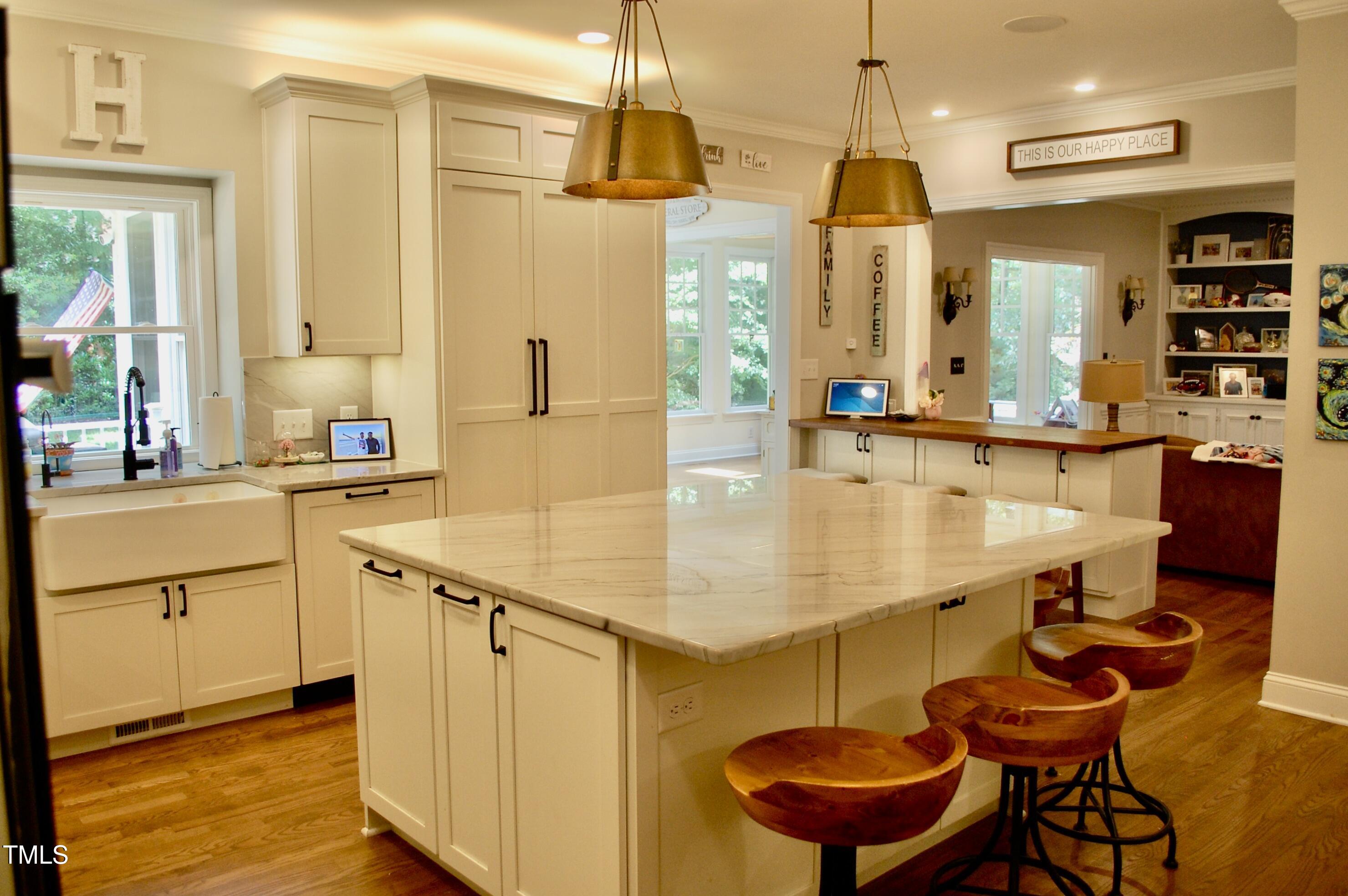 2216 Countrywood Road North Raleigh, NC 27615 - Photo 4 of 22 a kitchen with stainless steel appliances kitchen island granite countertop a table chairs in it and wooden floors