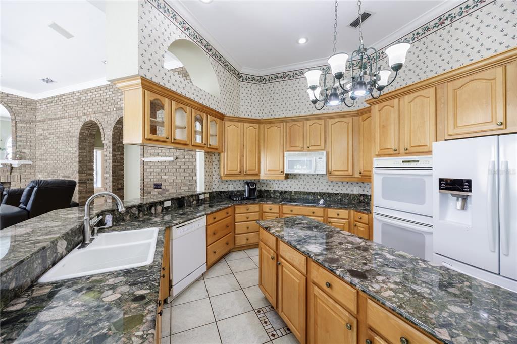 7513 Southwest 35th Way Gainesville, FL 32608 - Photo 14 of 38 a kitchen with a sink stove and refrigerator
