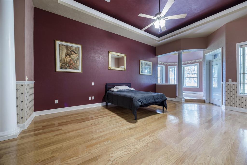 7513 Southwest 35th Way Gainesville, FL 32608 - Photo 17 of 38 a spacious bedroom with a bed and wooden floor
