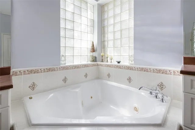 a white bath tub sitting in a bathroom next to a window