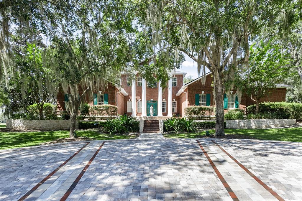 7513 Southwest 35th Way Gainesville, FL 32608 - Photo 3 of 38 a view of a brick house with a yard and large trees