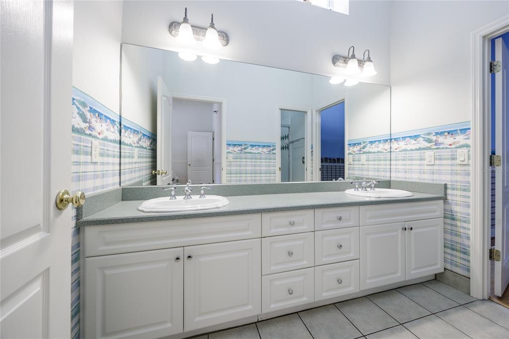 7513 Southwest 35th Way Gainesville, FL 32608 - Photo 31 of 38 a bathroom with a double vanity sink and a mirror