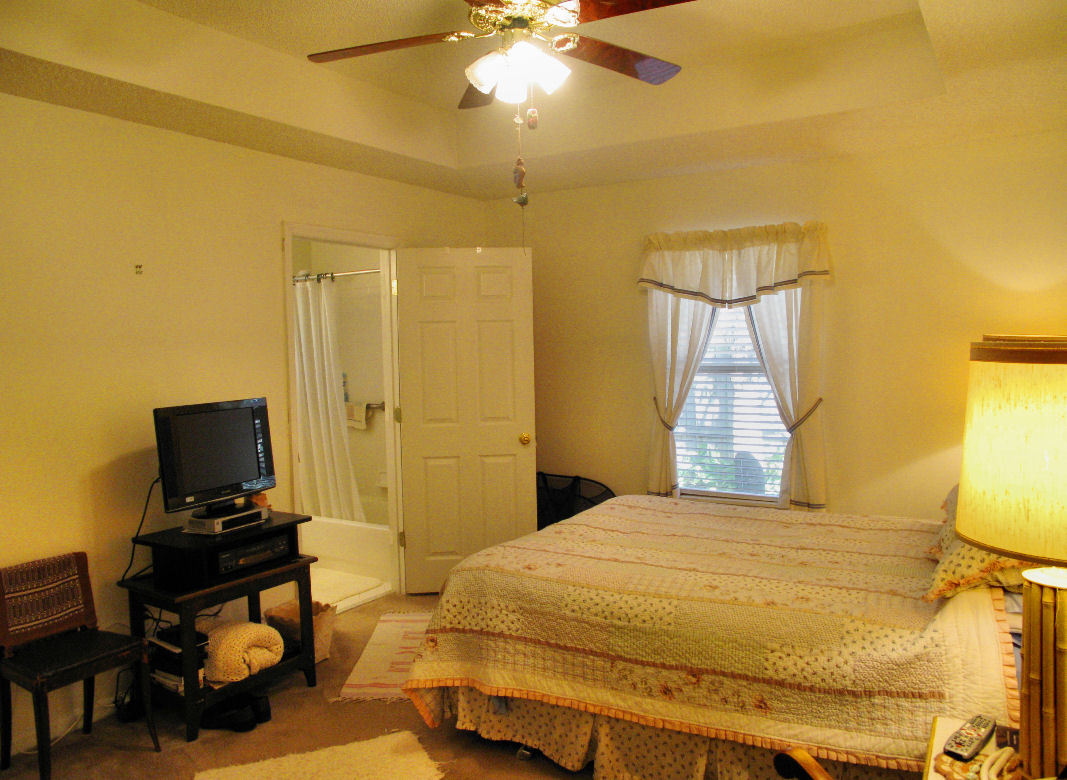 954 Stocks Street Atlantic Beach, FL 32233 - Photo 10 of 21 a bedroom with a bed and a chandelier