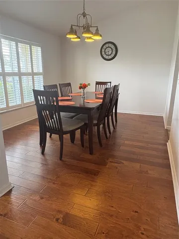 a view of a dining room with furniture a chandelier and wooden floor