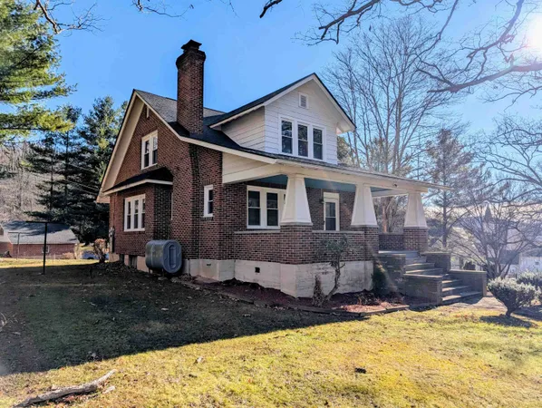 a front view of a house with a yard covered with snow