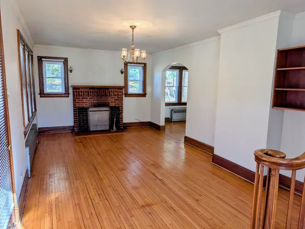 a view of empty room with a fireplace and wooden floor