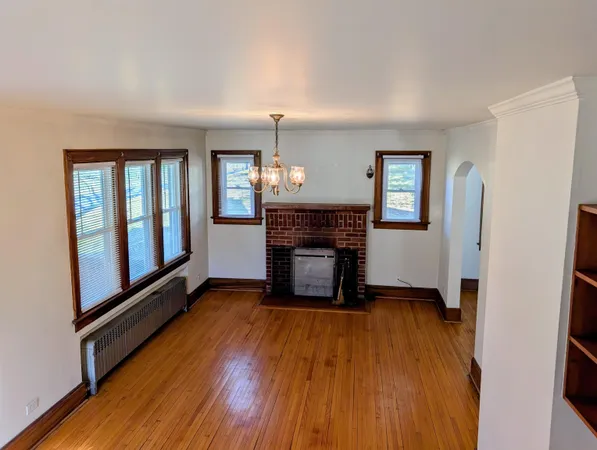 a view of a livingroom with wooden floor and a fireplace
